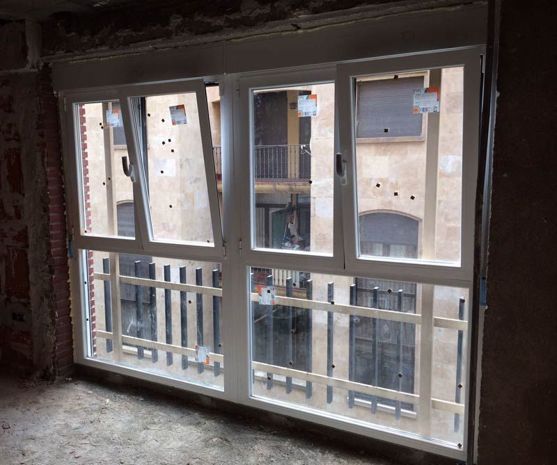 Una habitación con muchas ventanas y balcón.