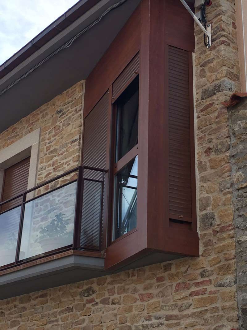 Un edificio de ladrillo con un balcón y una ventana.