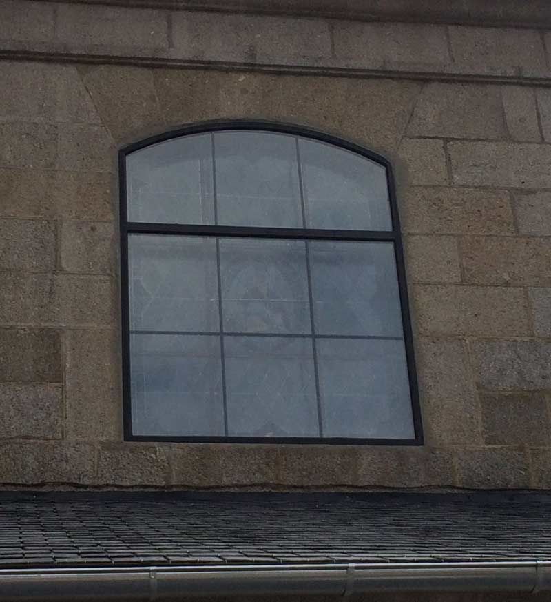 Una gran ventana en el lateral de un edificio de ladrillo.
