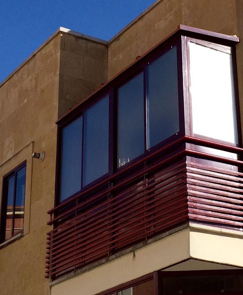 Un edificio con un balcón con una pantalla blanca encima.