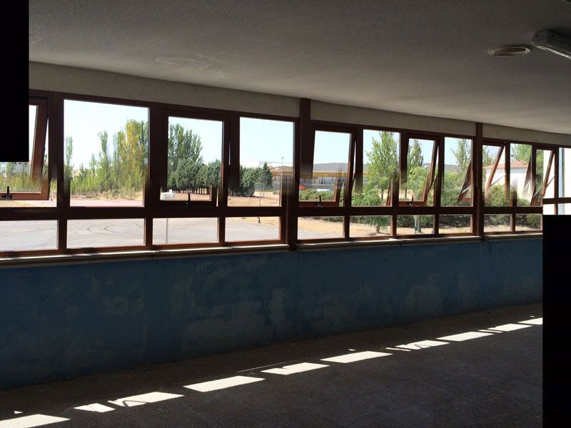 Una habitación con muchas ventanas y una pared azul.