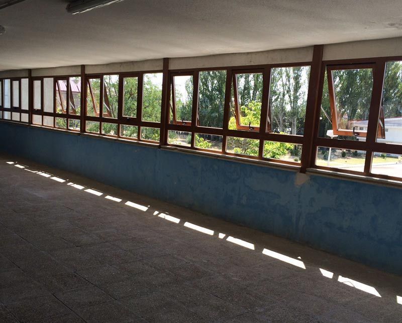 Una habitación con muchas ventanas y una pared azul.