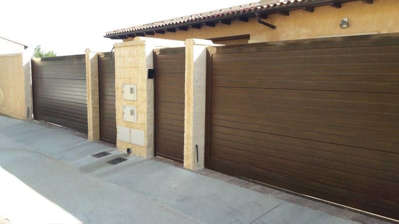 Una casa con una valla marrón y una puerta