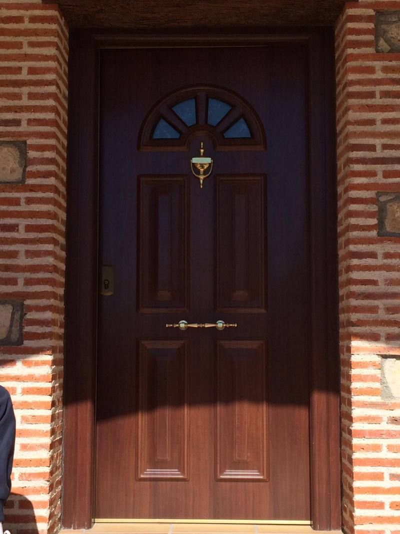 Una puerta de madera con una pared de ladrillos detrás