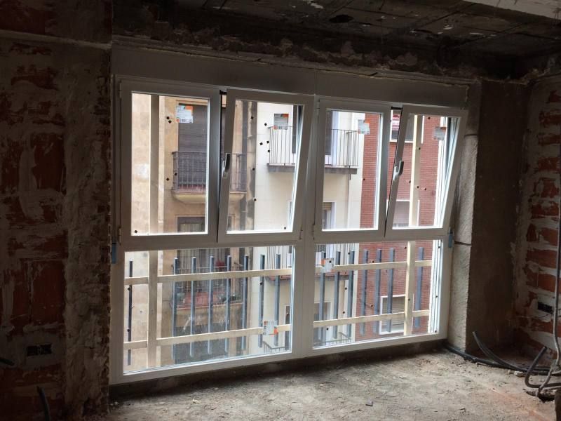 Una habitación con una ventana grande y una pared de ladrillo.