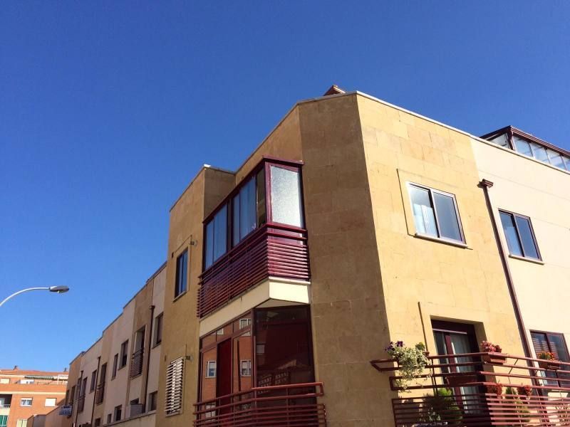 Un edificio con un balcón y un cielo azul al fondo.