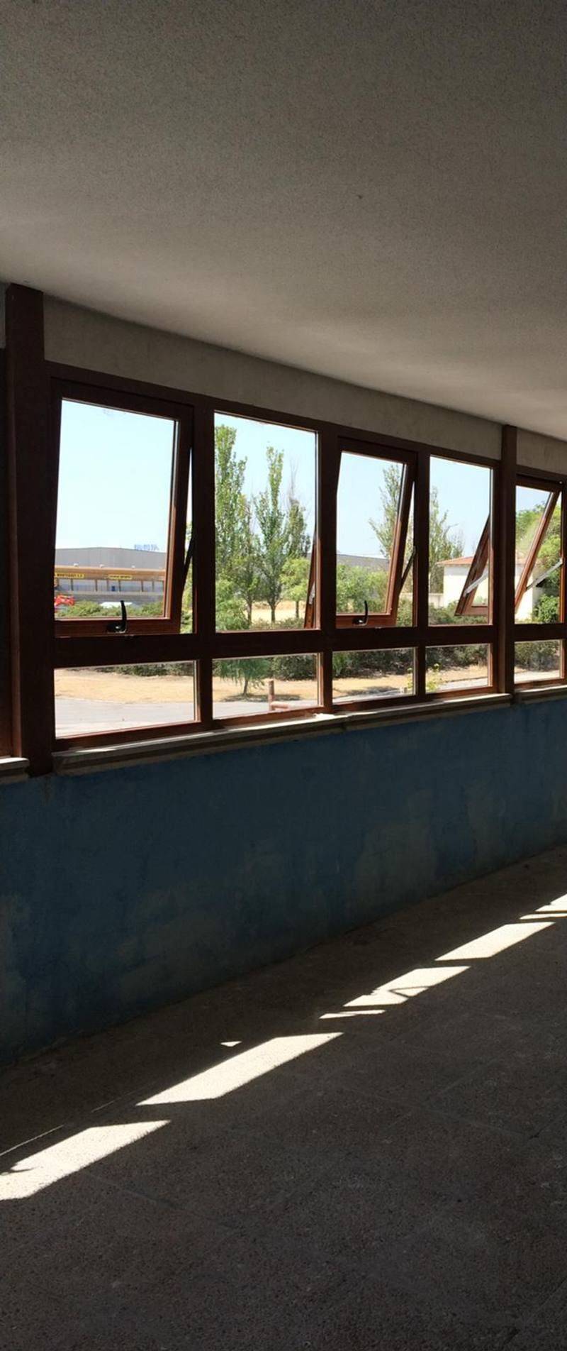 Una habitación con muchas ventanas y una pared azul.