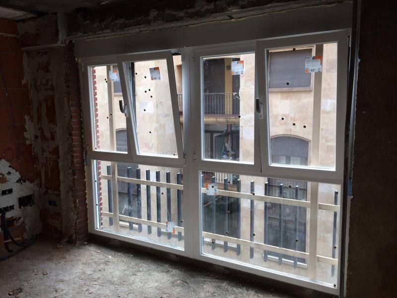 Una habitación con una gran ventana y un balcón.