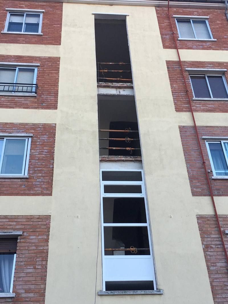 Un edificio de ladrillo con un balcón en el piso superior.