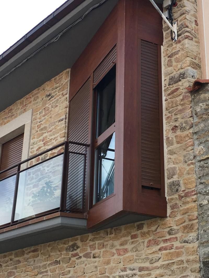 Un edificio de ladrillo con un balcón y una ventana.