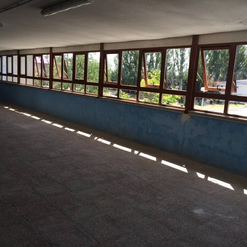 Una habitación con muchas ventanas y una pared azul.