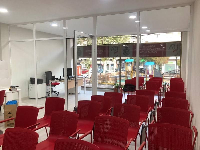 Una fila de sillas rojas están alineadas en una habitación.