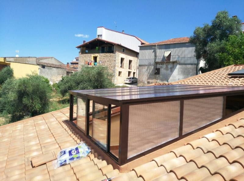 Un tejado con una ventana y un edificio al fondo.