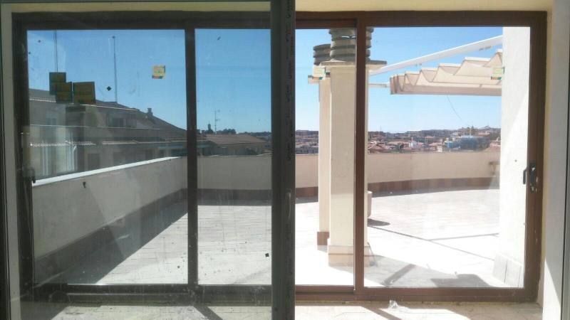 Una puerta corrediza de vidrio con vista a una azotea.