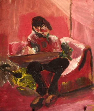 Persona sentada en un sofá rosa, sosteniendo una bandeja en una habitación de tonos rojos.