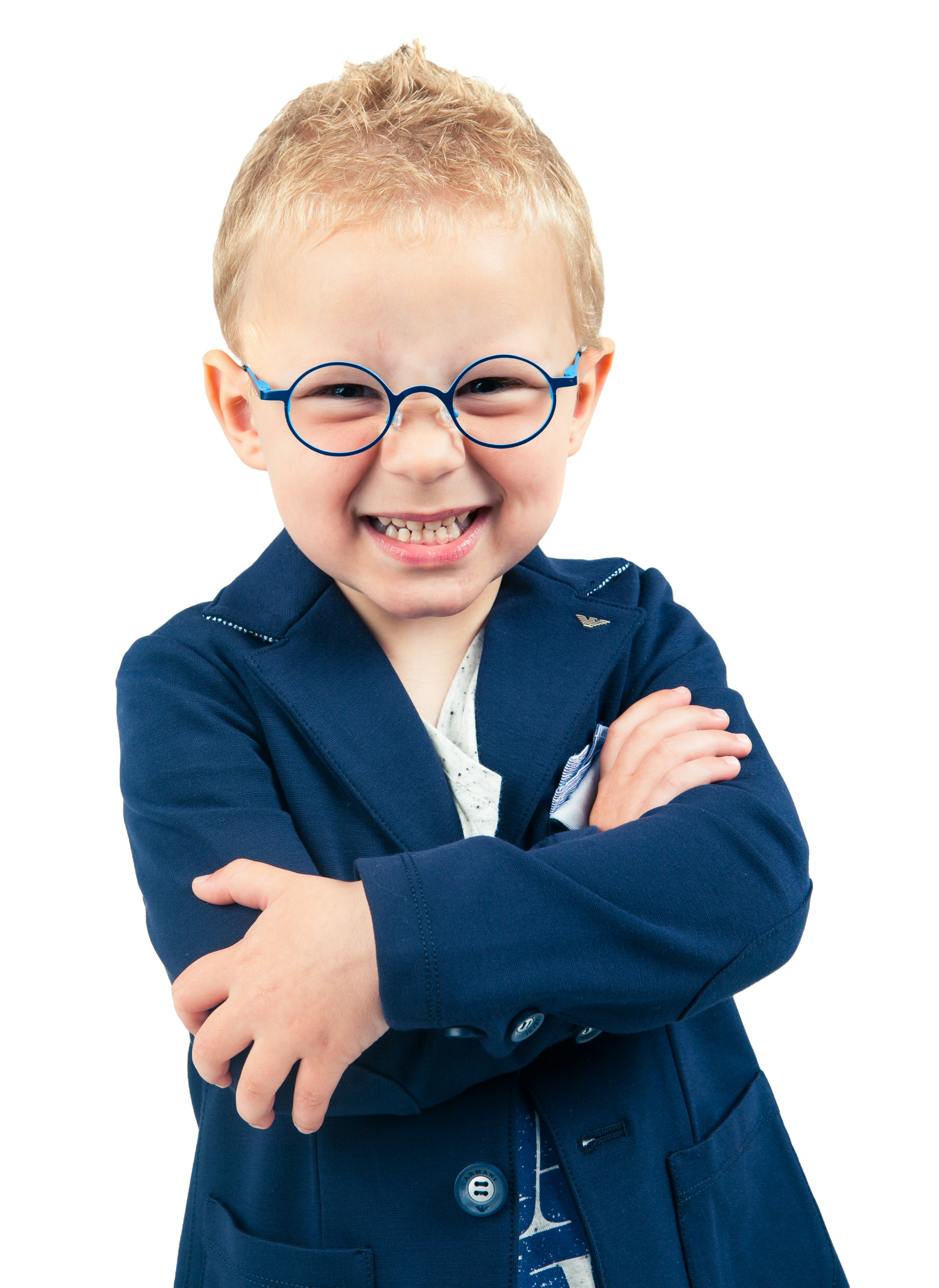 Enfant souriant portant des lunettes et un blazer bleu, les bras croisés.