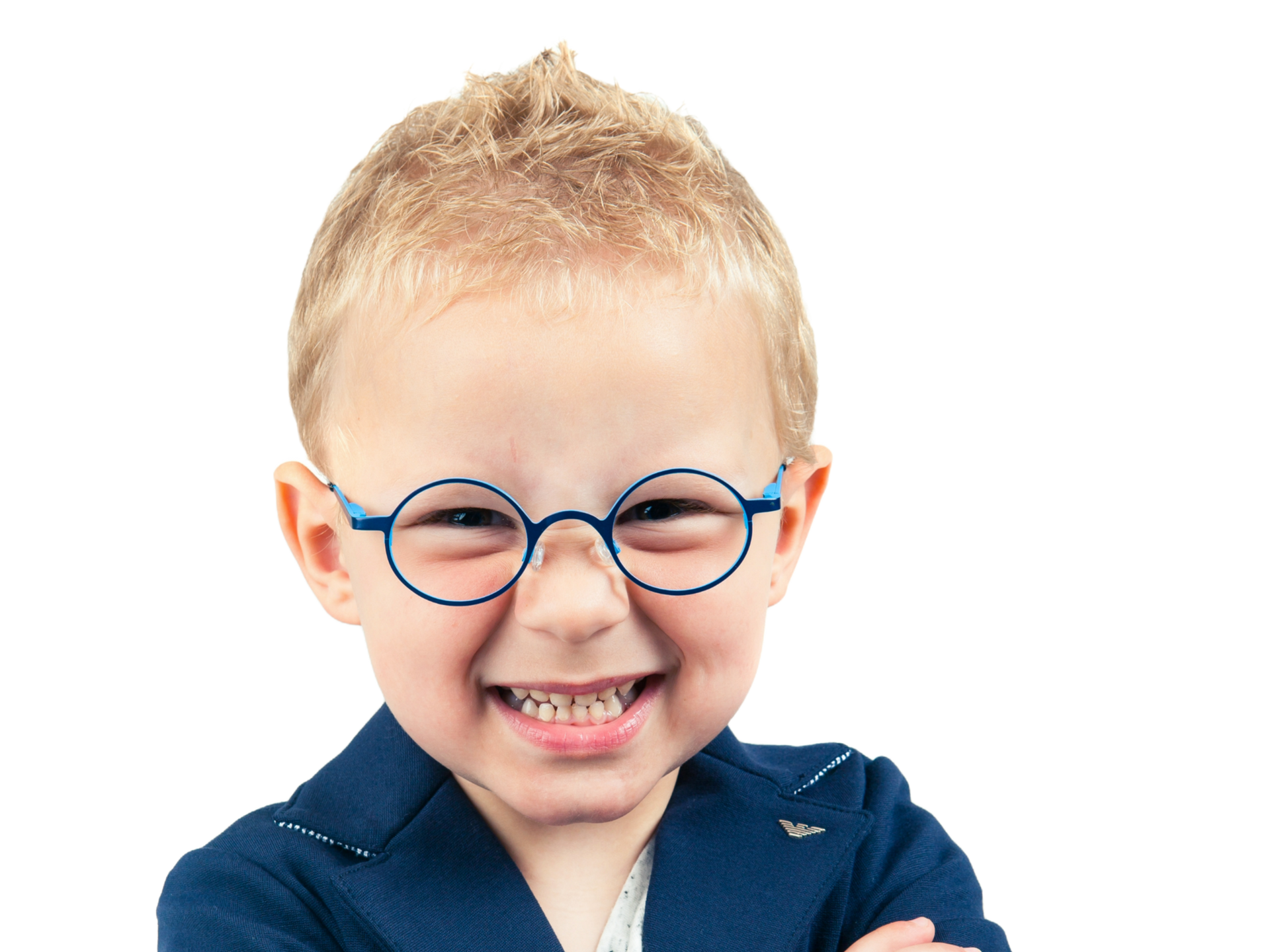 Un enfant souriant, aux cheveux blonds en piques et portant des lunettes rondes bleues, est vêtu d'un blazer bleu.