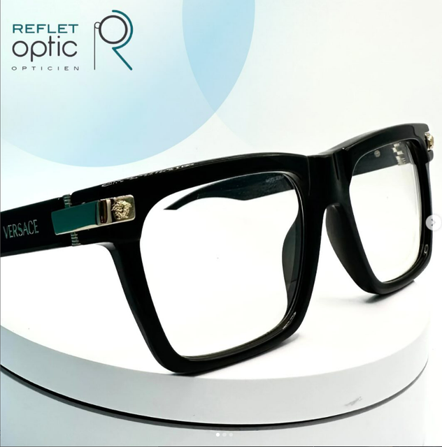 Lunettes de vue Versace noires sur une plateforme blanche.