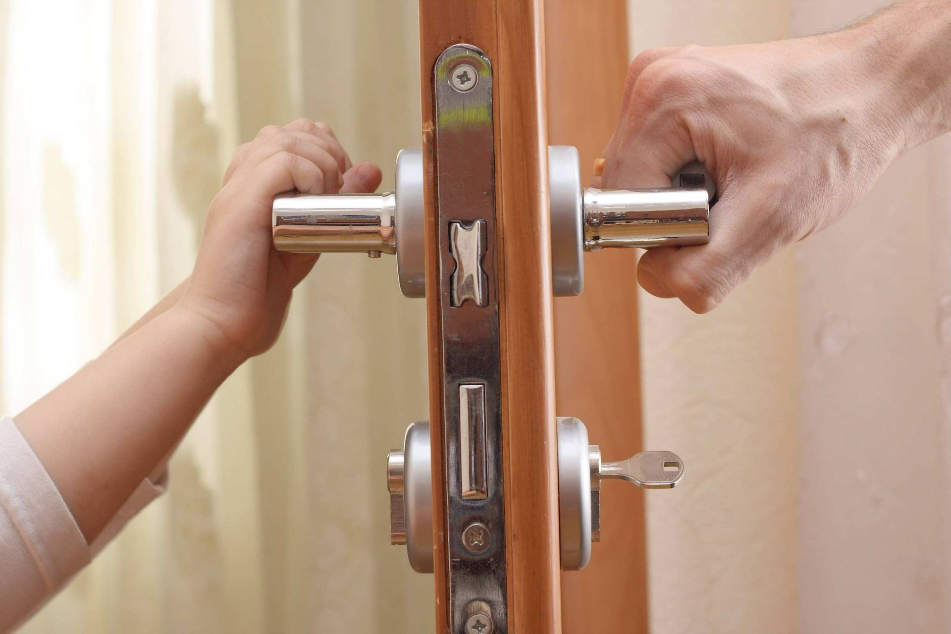 Una persona está abriendo una puerta con la mano de un niño.