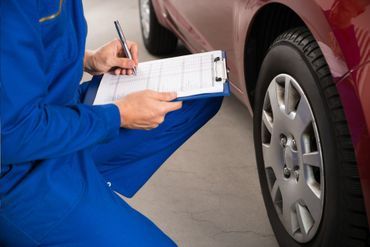 Detailaufnahme eines Kfz-Mechanikers bei der Arbeit im Motorraum.