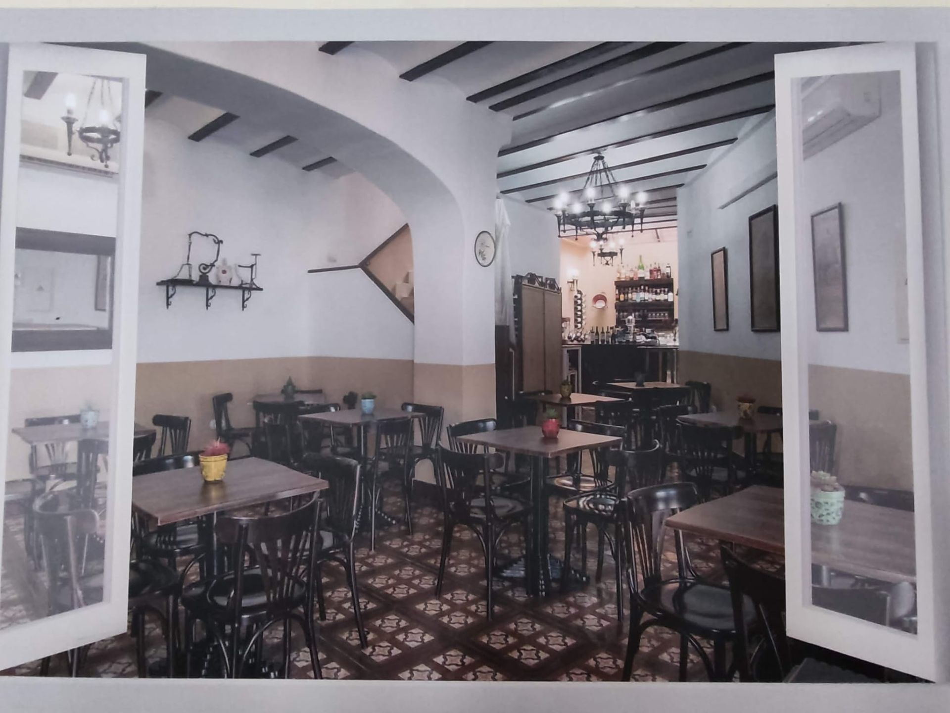 Un restaurante con mesas y sillas con las puertas abiertas.