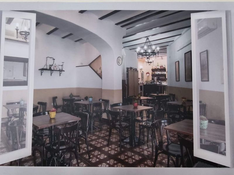 Un restaurante con mesas y sillas con las puertas abiertas.
