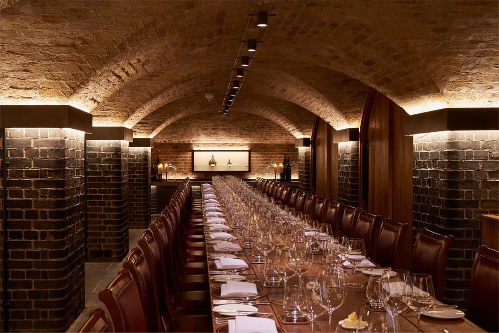 Una mesa larga con muchas copas de vino encima.