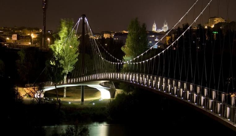 Un puente sobre un río por la noche con luces.