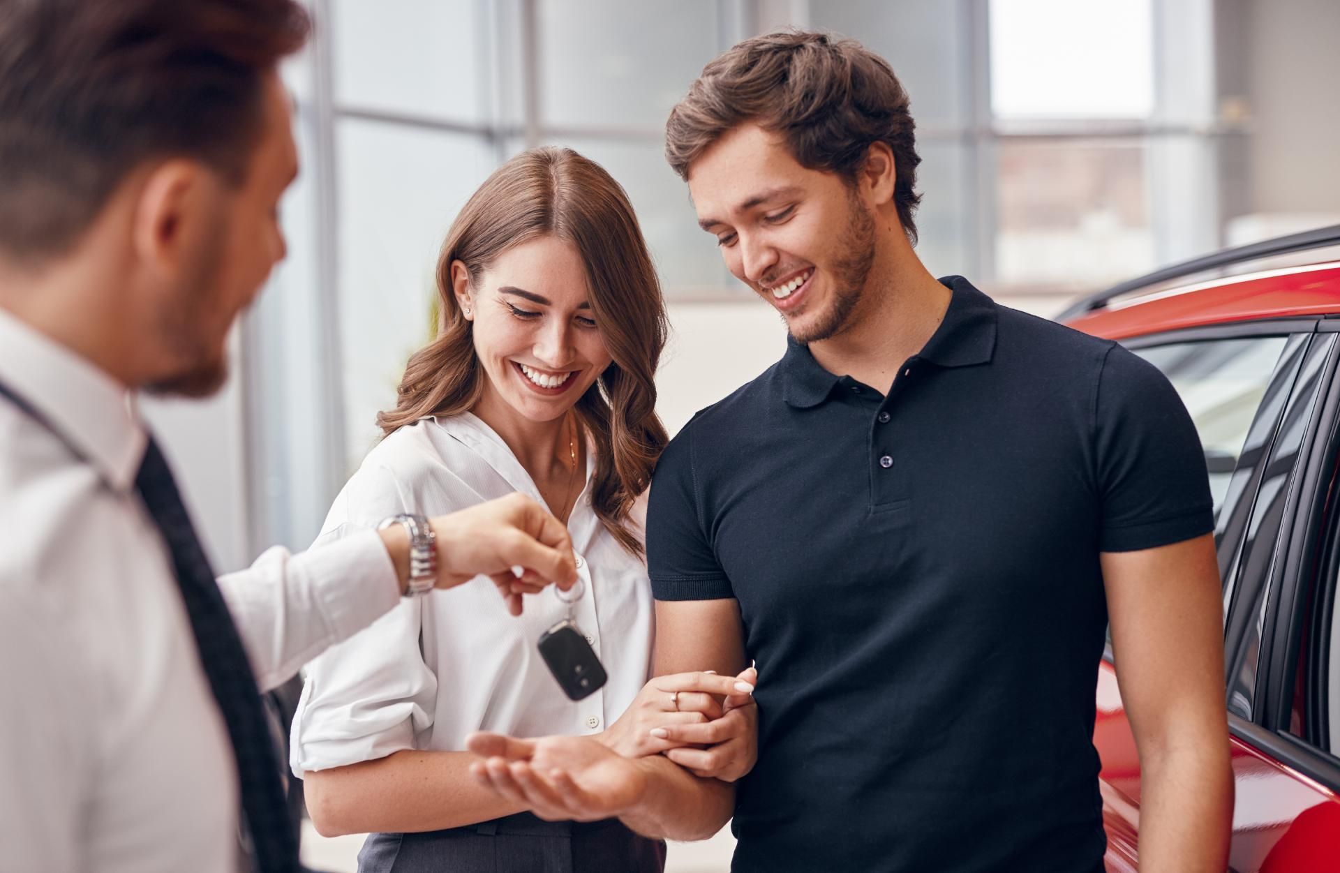 Automobilkaufmann verkauft ein Auto an einen Paar