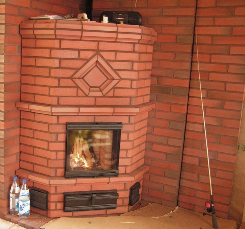 punatiilinen takka kohokuvioinnilla