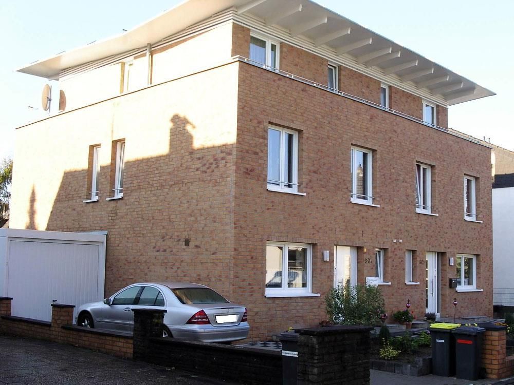 Ein Auto steht vor einem großen Backsteingebäude