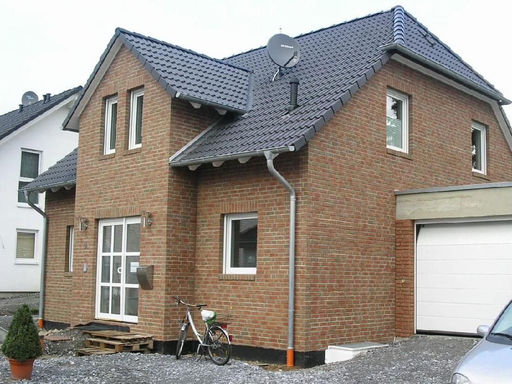 Ein Backsteinhaus mit einer Satellitenschüssel auf dem Dach