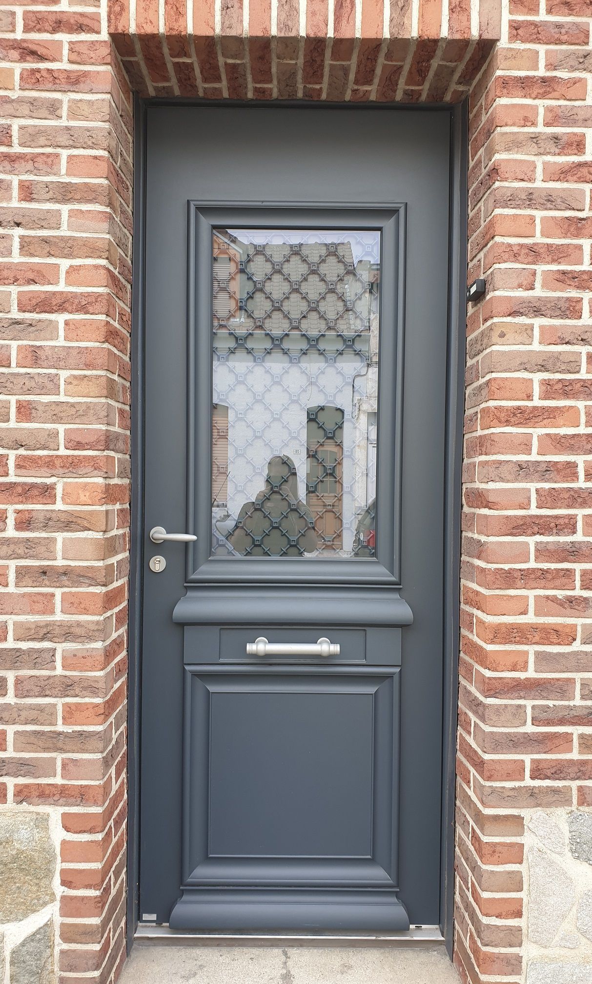 Porte d'entrée en aluminium gris anthracite RAL 7016. Fabricant BELM, modèle ATHENA. Porte avec grille.