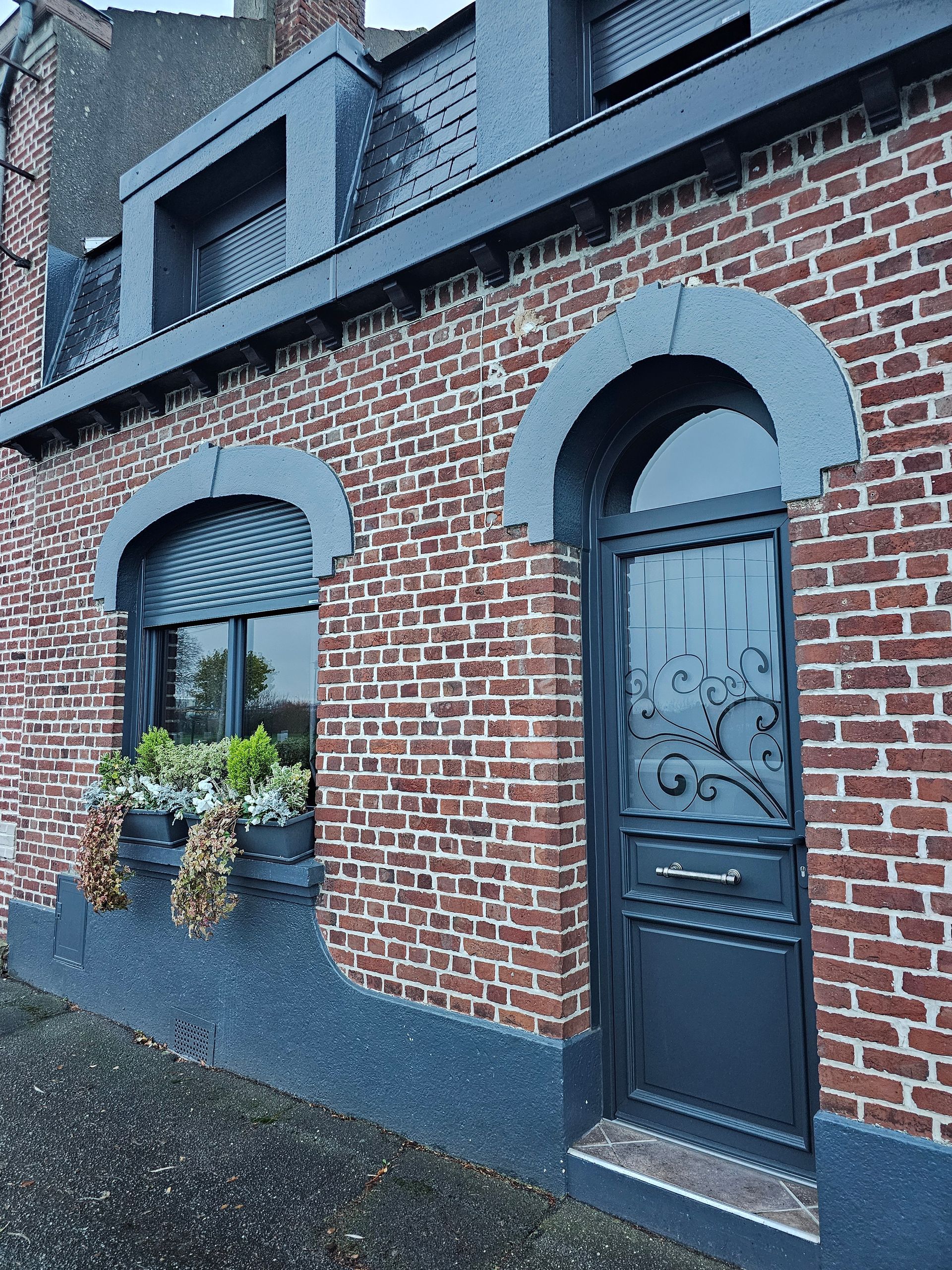 Porte d'entrée en PVC gris anthracité RAL 7016. imposte plein cintre. fenêtres avec volets roulants incorporés.
