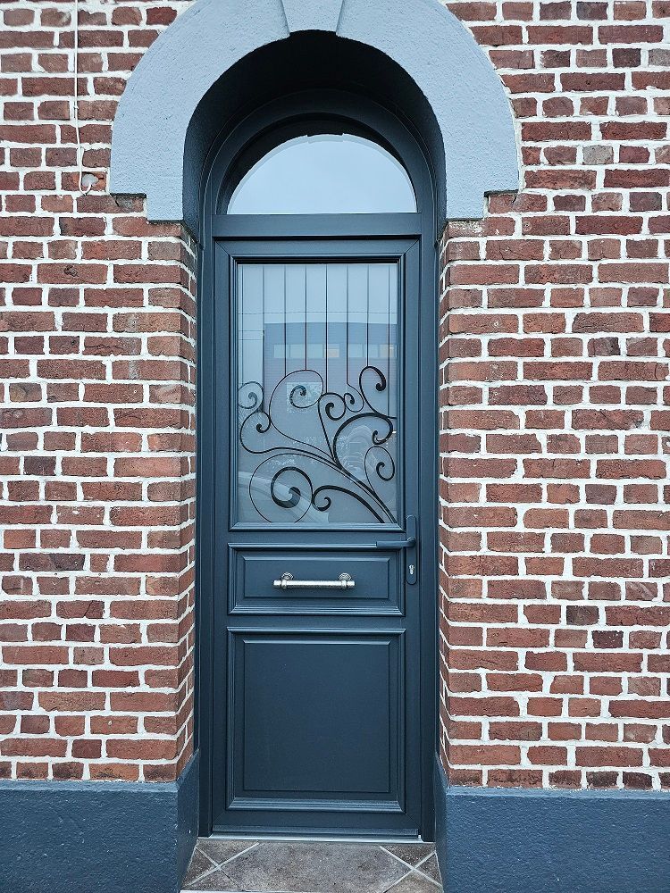 Porte d'entrée PVC filmé gris anthracite RAL 7016 avec imposte fixe vitrée de forme plein cintre. Fabricant PIERRET.