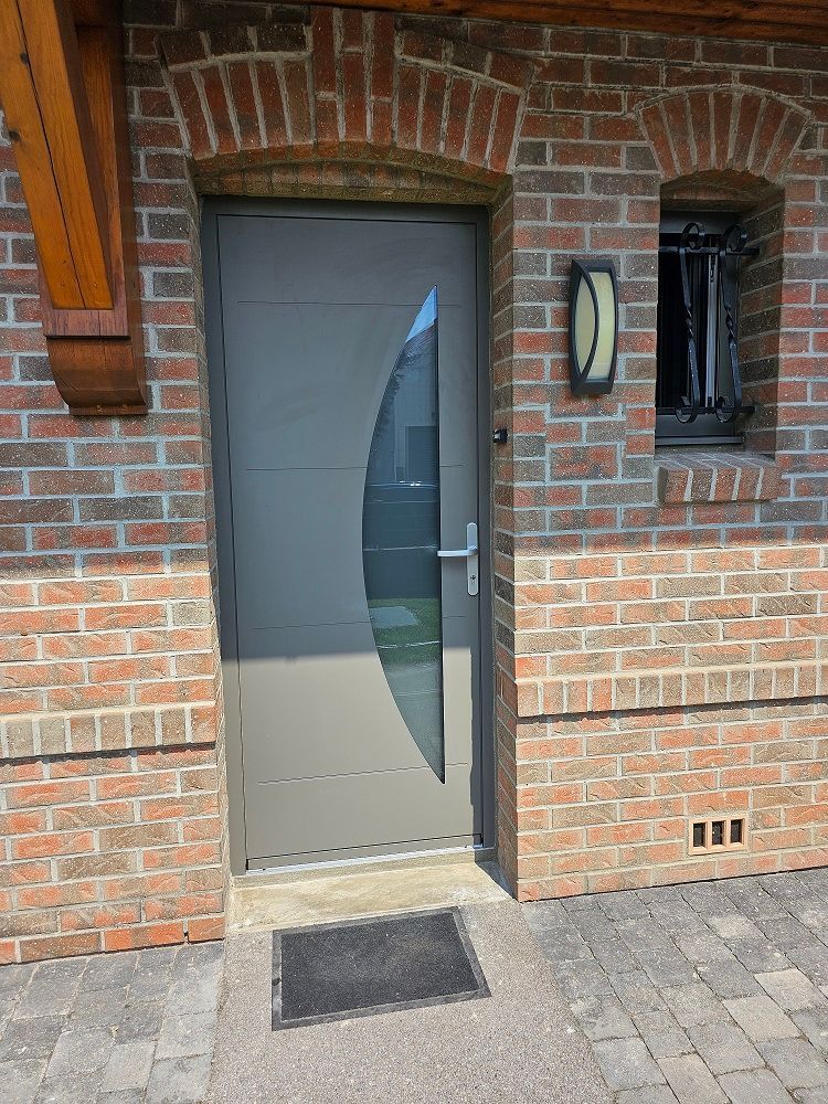 Porte d'entrée en ALUMINIUM laqué gris quartz RAL 7039. Modèle demi lune. Fabricant PIERRET.