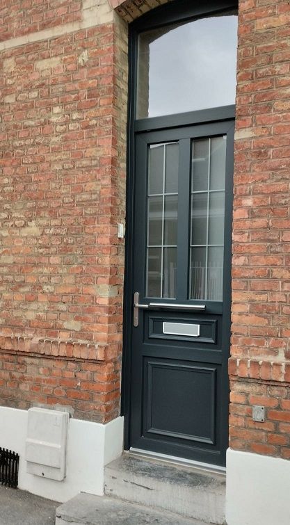 Porte d'entrée en PVC gris anthracite RAL 7016. Modèle demi vitré avec meneau central. Croisillons plomb. Insert d'une boîte aux lettres. SELO.