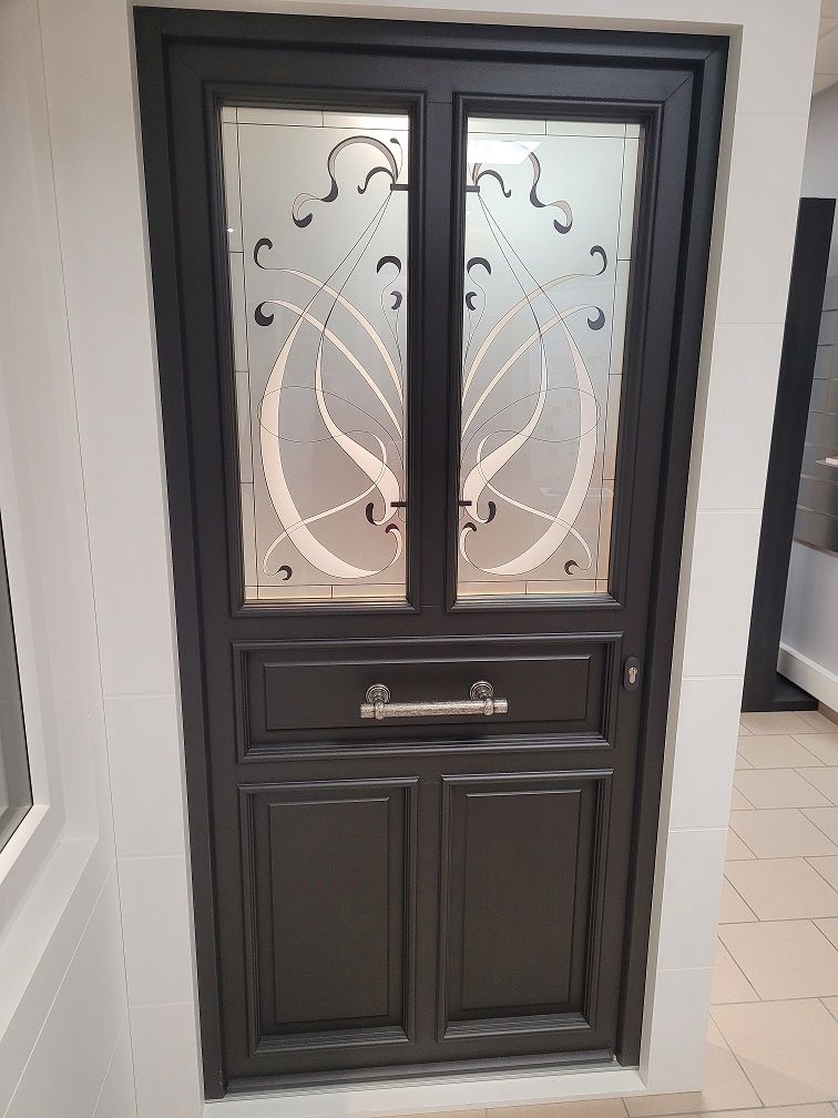 Porte d'entrée en PVC filmé noir RAL 9005. Modèle demi vitré avec meneau central. Poignée de tirage horizontal. PIERRET.