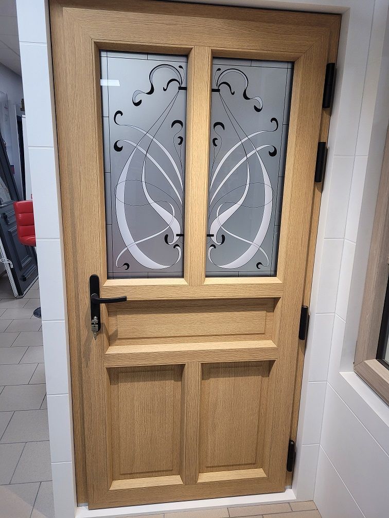 Porte d'entrée en PVC filmé chêne clair intérieur. Modèle demi vitré avec meneau central. PIERRET.