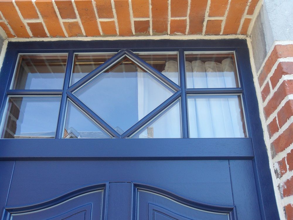 Zoom sur le trumeau vitrée de la porte bleue.  Fabricant PIERRET.