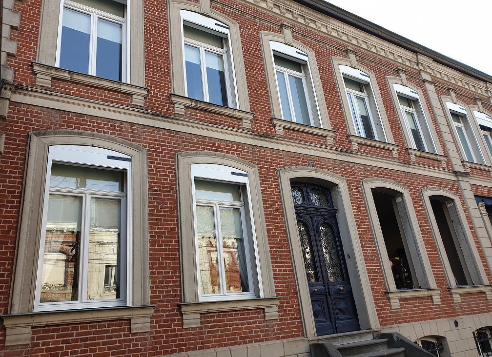 Menuiseries PVC en blanc avec impostes fixes vitrées et volets roulants solaires