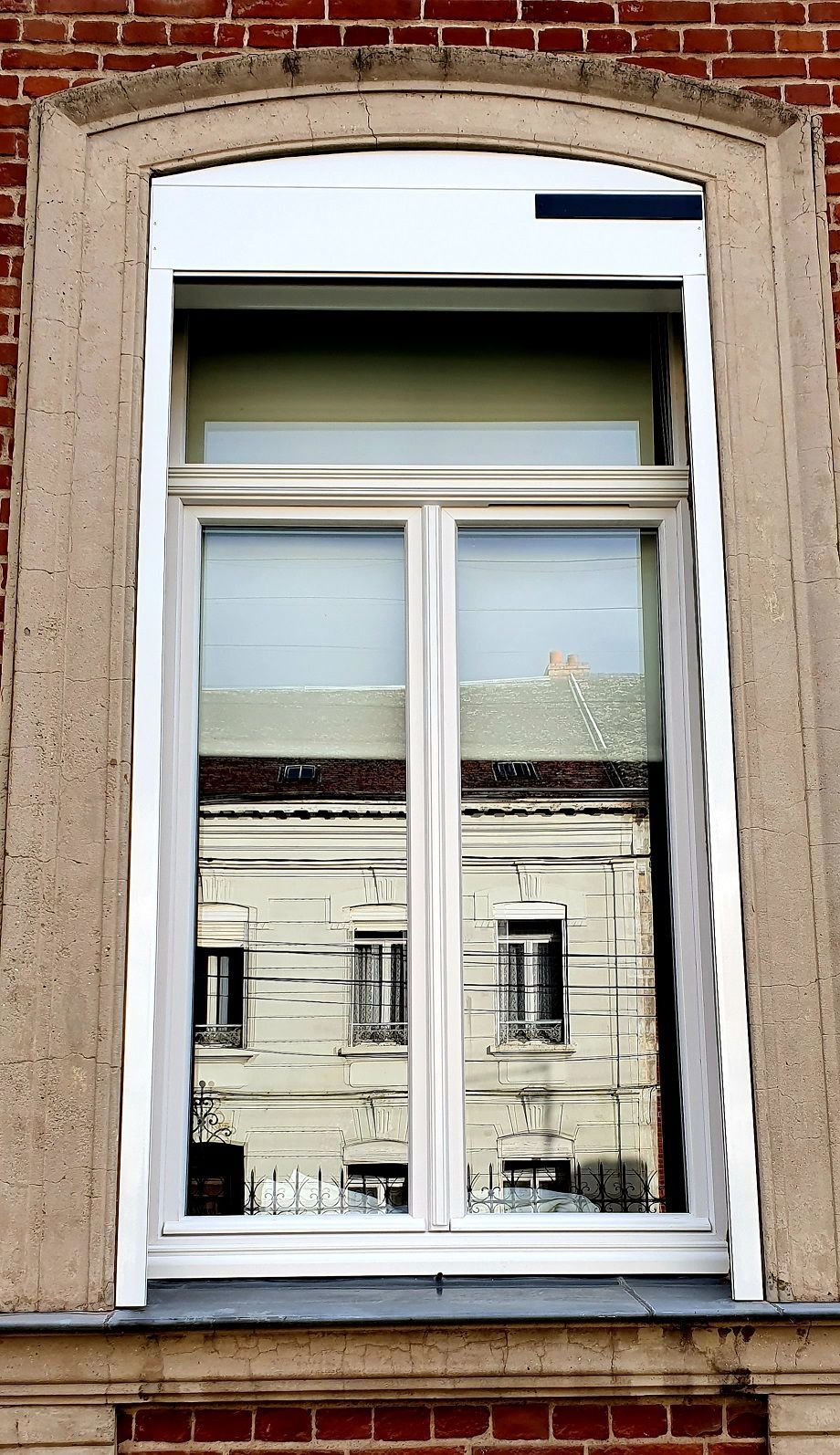 Menuiseries PVC en blanc avec impostes fixes vitrées et volets roulants solaires