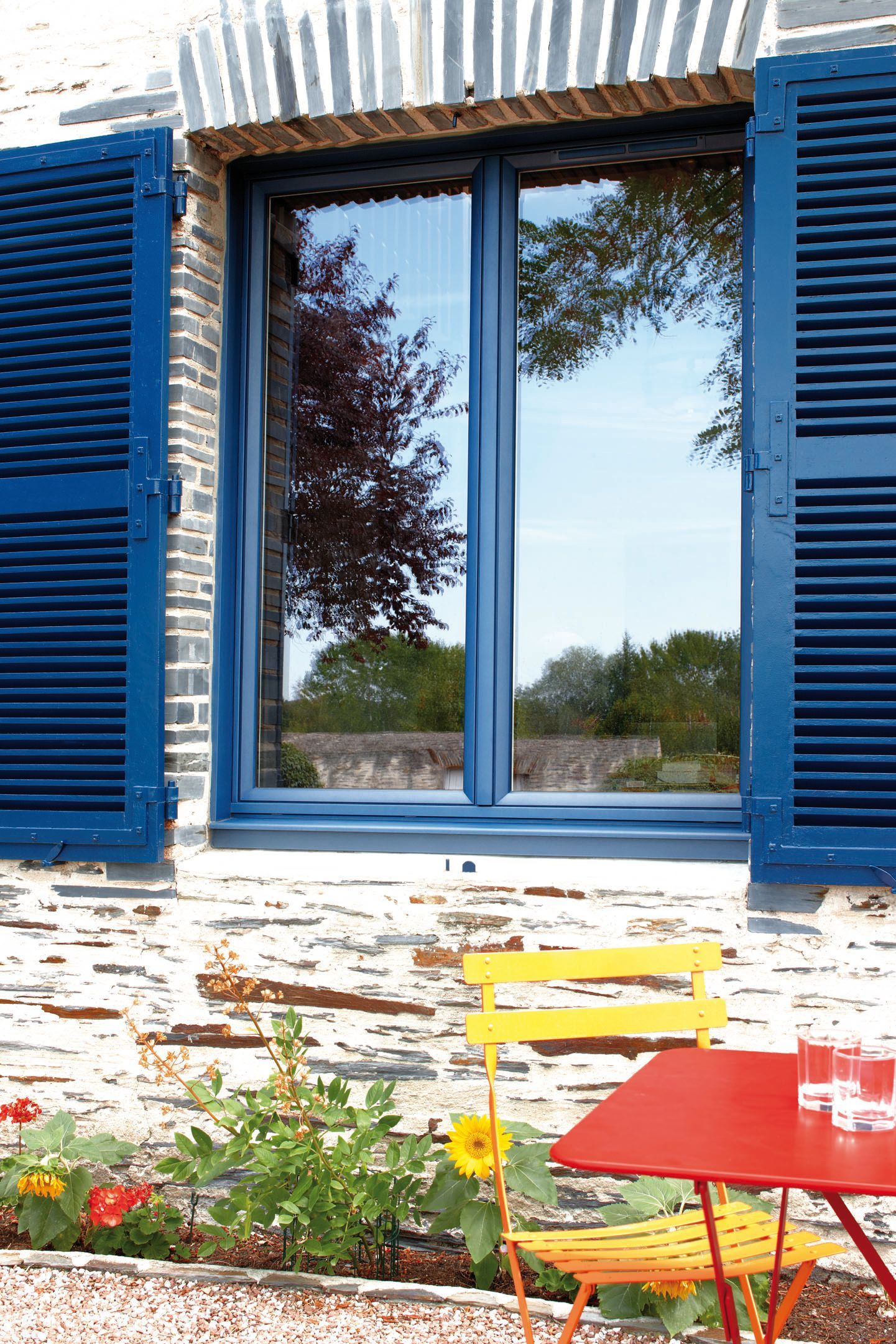 Volets battants en aluminium bleu. Lames persiennées.