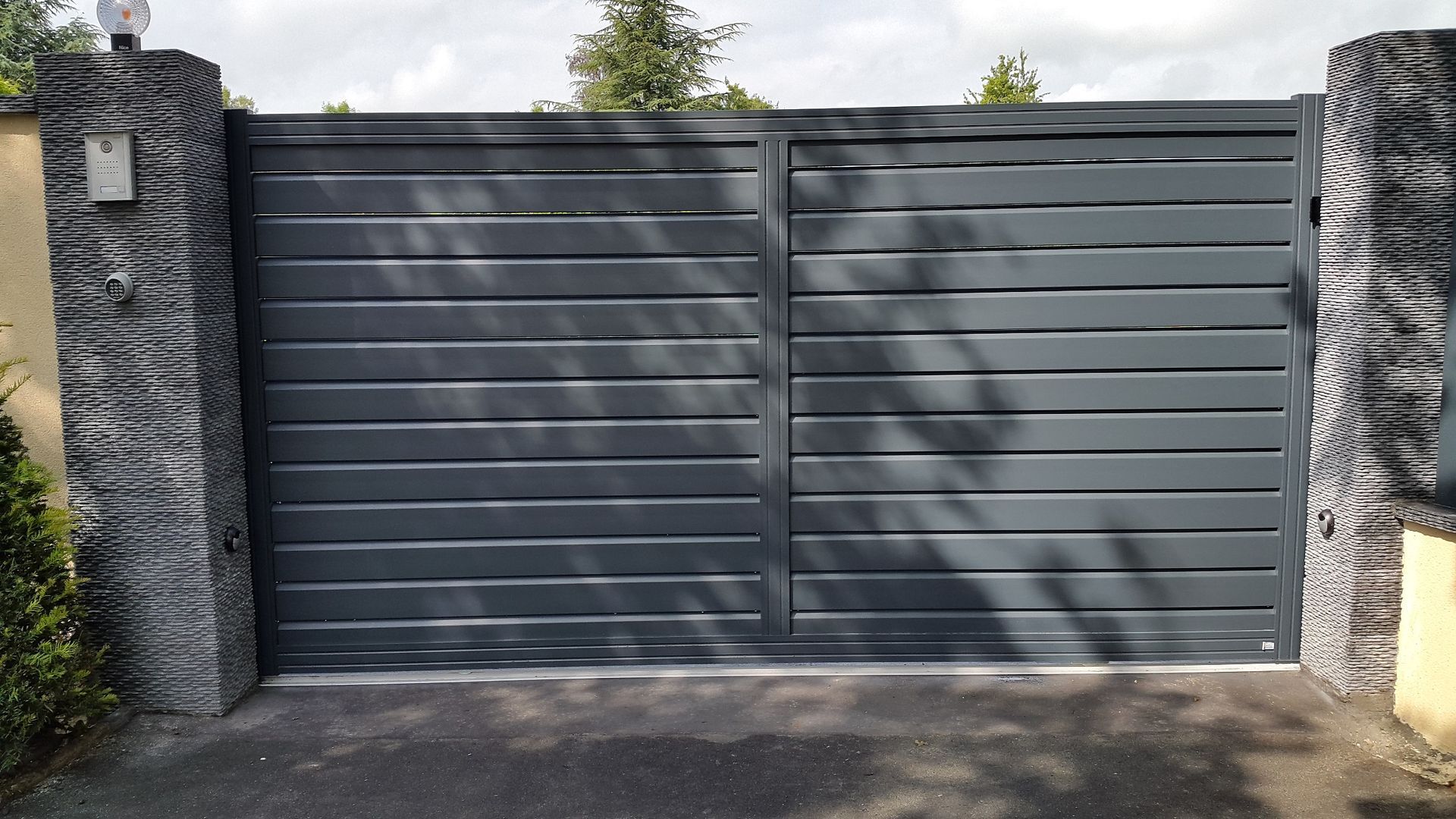 Portail double battant en aluminium gris RAL 7016