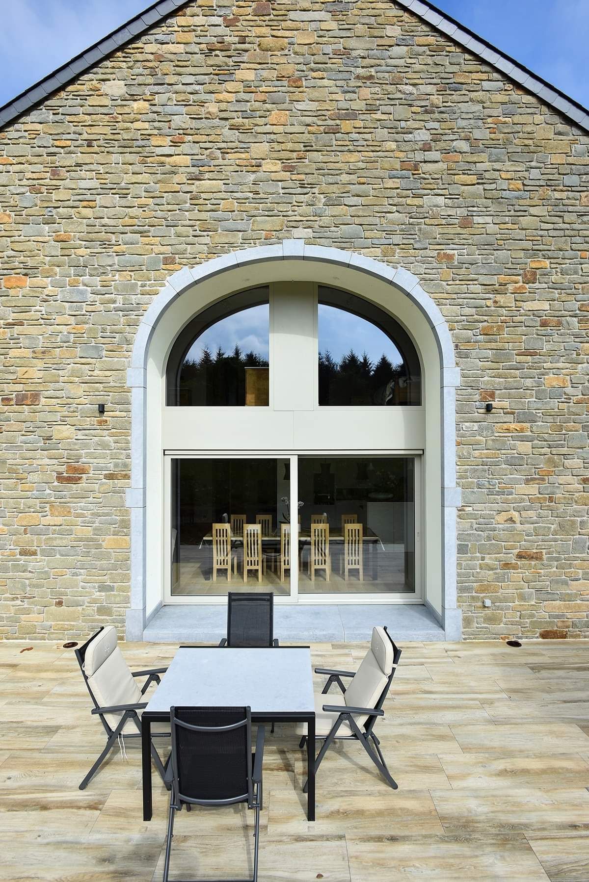 Baie vitrée donnant sur une terrasse avec une arche. aluminium.