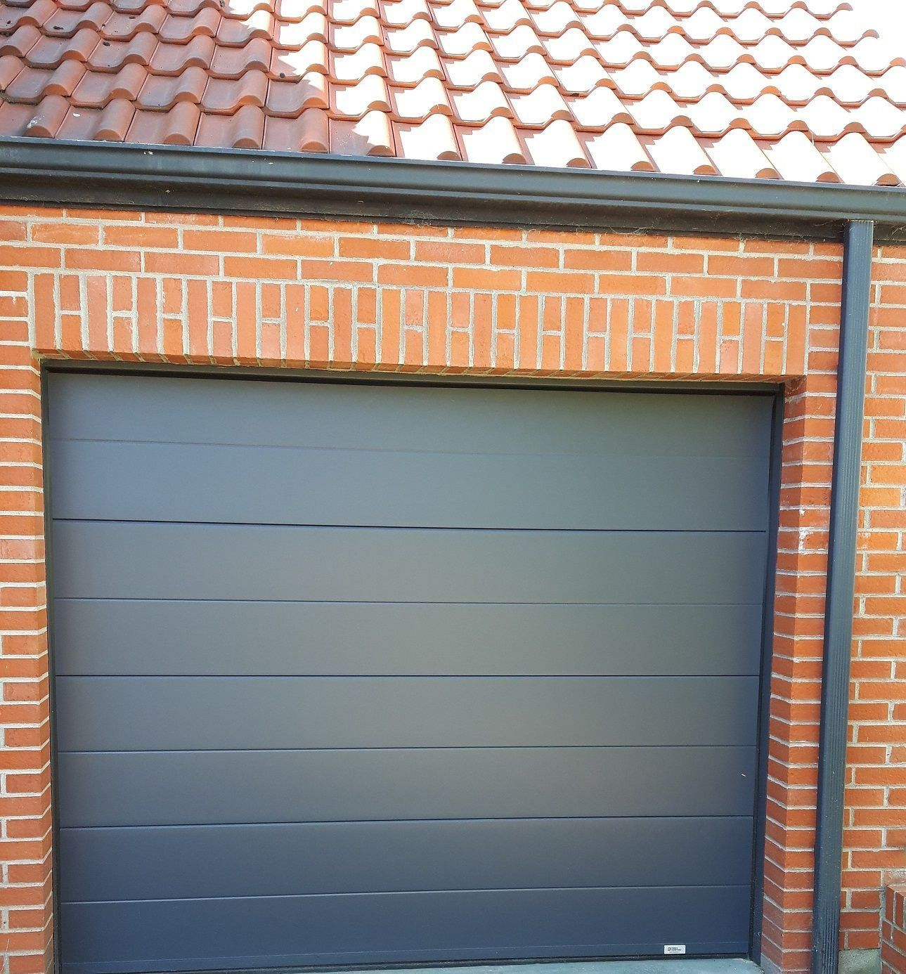 Porte de garage sectionnelle plafond motorisée. Panneaux rainurés.