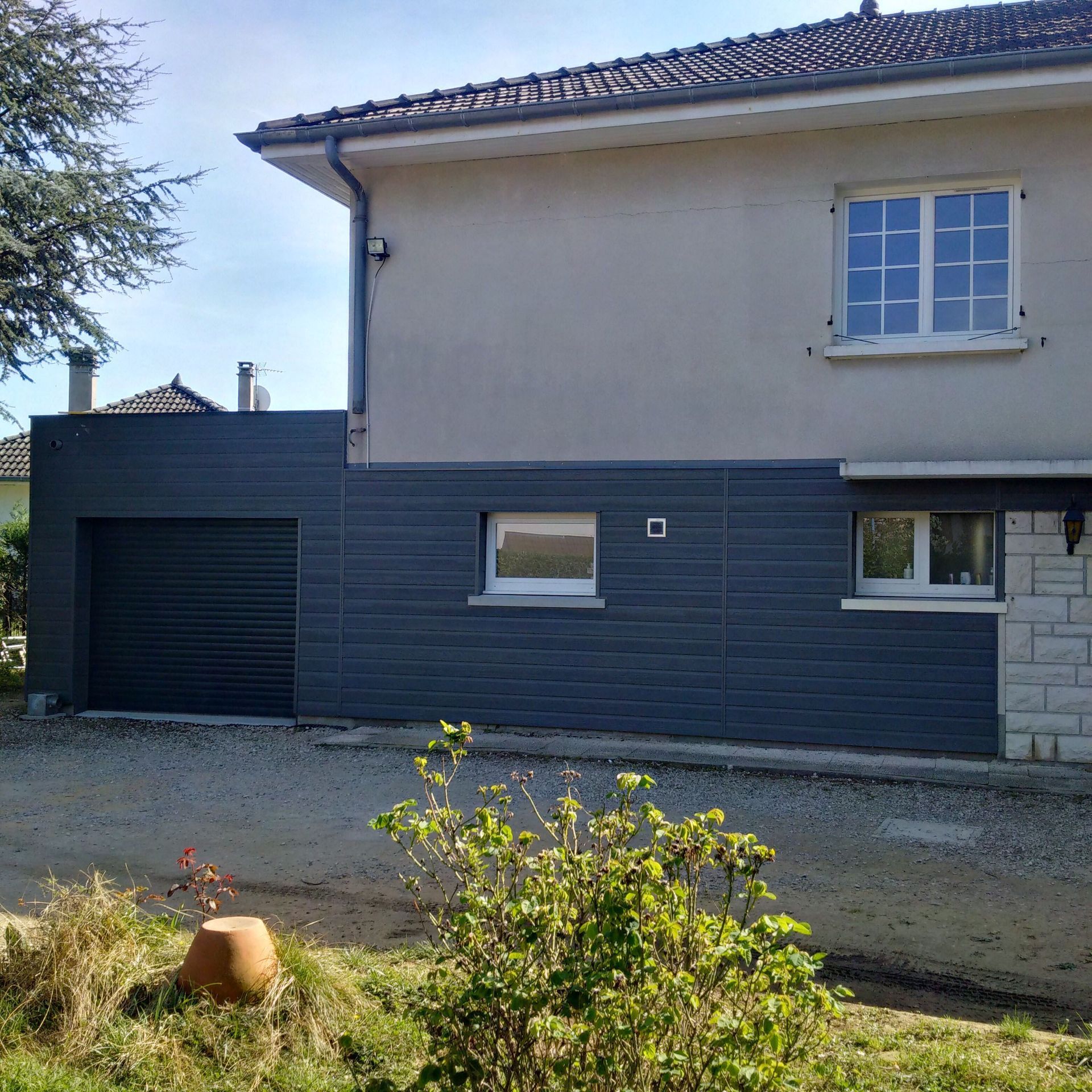 Bardage en bois composite gris sur maison et une extension de garage