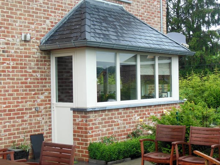 Fenêtres et porte de service en PVC blanc sur une petite extension de maison