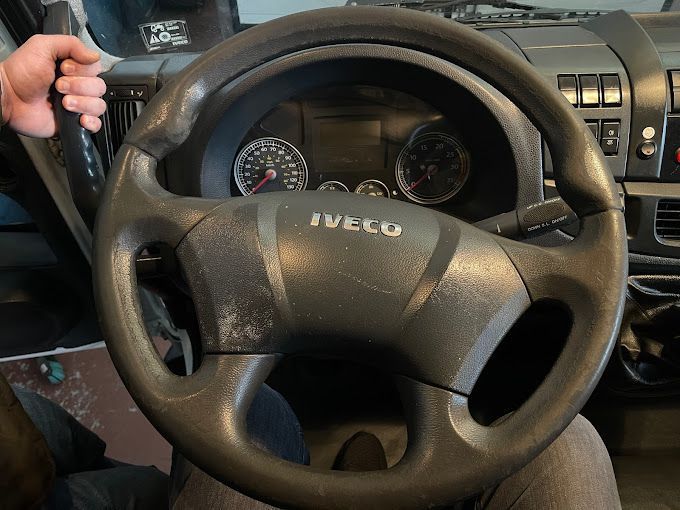 Una persona sostiene el volante de un camión Iveco.
