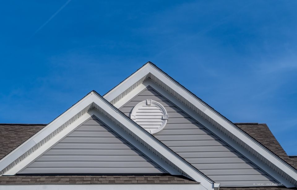 Gerüst an einem schwarz-weißen Fachwerkhaus vor blauem Himmel.